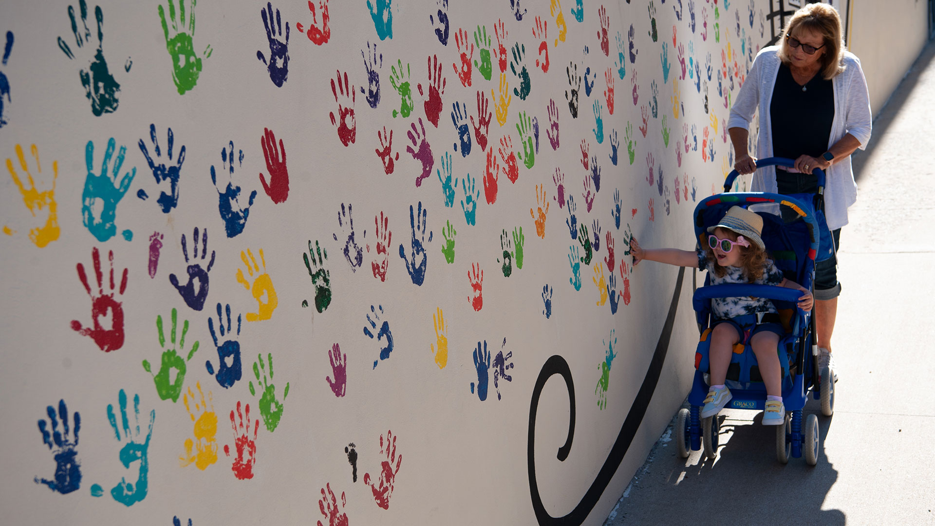A woman and her grandchild look at a mural in Monmouth